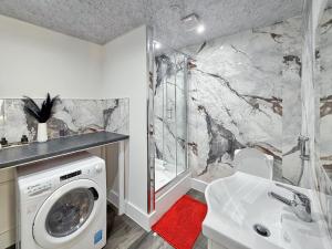 a bathroom with a washing machine and a sink at Bletchley Retreat in Bletchley