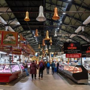 a group of people walking through a market with lights at 1BD Plus Den Lakeview Suite - Steps to CN Tower & Rogers Centre - Free Parking in Toronto