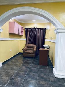 a waiting room with a chair and a sink at Executive 2BR at Redemption Camp in Loburo
