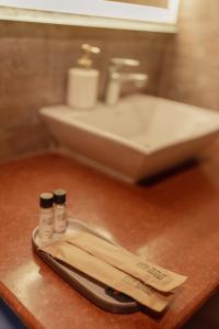 a bathroom counter with a sink and two bottles of medicine at Wild Woods Tiger Resort in Nagpur +105 photos