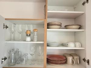 ein Schrank voller Gläser, Teller und Schüsseln in der Unterkunft Landliebe in Mittenwald