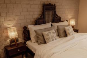 a bedroom with a bed with white sheets and pillows at Wild Woods Tiger Resort in Nagpur