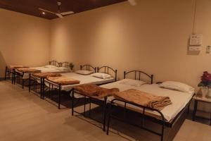 four beds lined up in a row in a room at Wild Woods Tiger Resort in Nagpur