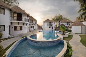a swimming pool in front of a villa at Treat Resort Rajkot in Rajkot