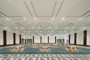 a large room with tables and chairs in it at Treat Resort Rajkot in Rajkot