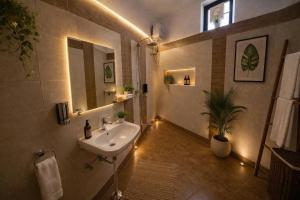 a bathroom with a sink and a mirror with lights at Badi Meadows By Wilkisto Near Fatehsagar Lake in Udaipur +54 photos