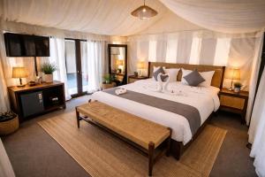 a bedroom with a large bed and a television at Badi Meadows By Wilkisto Near Fatehsagar Lake in Udaipur