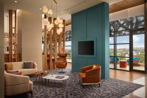 a living room with a blue wall and a tv at Hyatt Place Bhopal in Bhopal