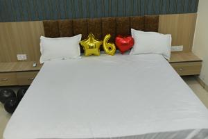 a white bed with two hearts and twoporting at Hotel KK Place in Chittaurgarh