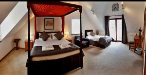 a bedroom with two beds and a canopy bed at Letterfinlay Lodge House in Letterfinlay