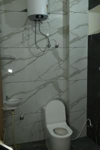 a bathroom with a toilet and a sink at Hotel KK Place in Chittaurgarh