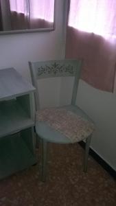 a green chair sitting in a room with a window at Bed Il Faro in Finale Ligure