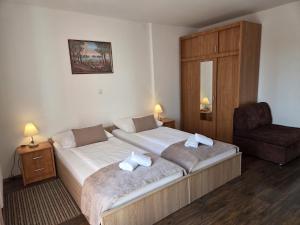 a hotel room with two beds and a chair at Plitvice Palace Rooms - Adults Only in Grabovac +51 photos