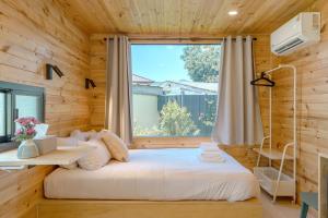 ein Schlafzimmer in einer Blockhütte mit einem großen Fenster in der Unterkunft Chambers in Phuket