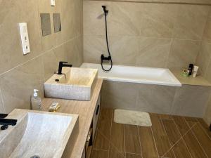 a bathroom with a sink and a bath tub at Tóth Vendégház in Nagykálló +11 photos