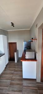 an empty kitchen with a counter and a refrigerator at Apex Ocean and Mountainview in Gordonʼs Bay +8 photos