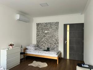 a bedroom with a bed and a wall at Tóth Vendégház in Nagykálló