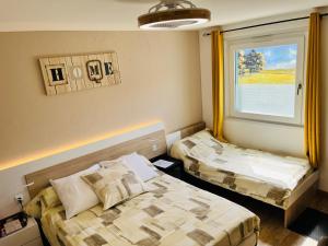 a small room with two beds and a window at L'auberge fleurie in Heilly