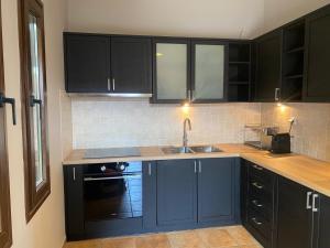 a kitchen with black cabinets and a sink at Villa Agali in Agia Anna +27 photos