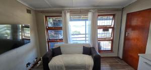 a room with a chair in front of a window at Apex Ocean and Mountainview in Gordonʼs Bay