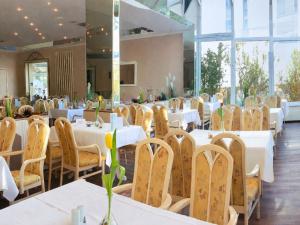 a dining room with white tables and chairs at R&R Hotel Störtebeker in Baabe +24 photos