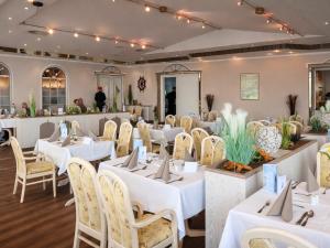 a dining room with white tables and chairs at R&R Hotel Störtebeker in Baabe