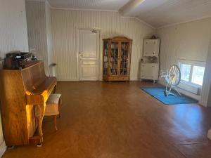 an empty living room with a piano and a window at Lantlivlodge i Österjörn -Herrgård in Österjörn