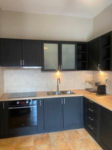 a kitchen with black cabinets and a sink at Villa Agali in Agia Anna