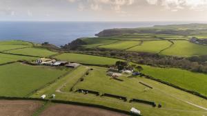an aerial view of a farm near the ocean at St Loy & Penberth Shepherds' Huts in Saint Buryan