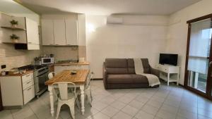 a kitchen and living room with a couch and a table at IL NIDO - Intero Appartamento Forum & Humanitas in Rozzano