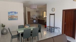 a dining room and living room with a table and chairs at Modern 2BR Apartment - Close to Gozo Ferry in Għajnsielem