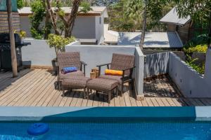 a patio with two chairs and a swimming pool at Quinta Esencia in Brasilito