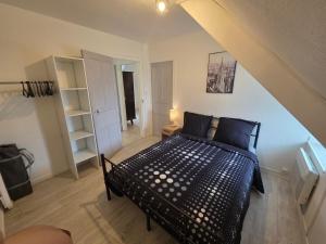 a bedroom with a black bed in a attic at Maison Bretagne Authentique in Plémy