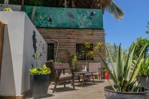 a patio with chairs and a table and plants at Quinta Esencia in Brasilito