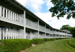 una vista exterior de un edificio blanco con patio en Country House Resort en Sister Bay