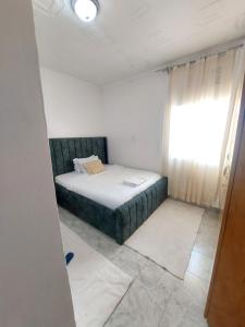 a bedroom with a bed in a room with a window at JJHomes in Eldoret