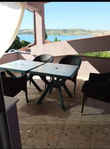 a table and chairs on a balcony with a view of the ocean at Apartmani Marija Rtina in Rtina