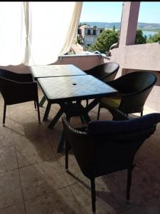 a wooden table and chairs on a balcony at Apartmani Marija Rtina in Rtina