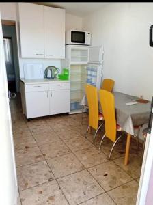a kitchen with a table and yellow chairs at Apartmani Marija Rtina in Rtina