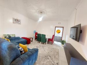 a living room with a blue couch and a table at JJHomes in Eldoret