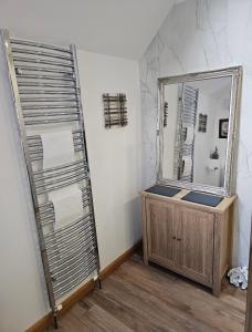 a bathroom with a mirror and a wooden dresser at Letterfinlay Lodge House in Letterfinlay