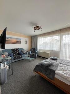 a bedroom with a bed and a living room at Studio Heimi I mit Balkon strandnah Cuxhaven-Grimmershörnerbucht in Cuxhaven