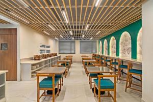 a dining room with tables and chairs and green walls at Country Inn Smart Stays, Rishikesh at Tapovan in Rishīkesh