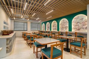 a dining room with wooden tables and chairs at Country Inn Smart Stays, Rishikesh at Tapovan in Rishīkesh