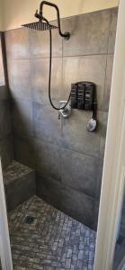 a shower in a bathroom with a phone at Apex Ocean and Mountainview in Gordonʼs Bay