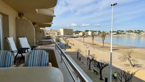 a balcony with chairs and a beach and water at La Llongada 2-C in L'Escala