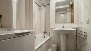 a white bathroom with a sink and a bath tub at La Llongada 2-C in L'Escala +23 photos
