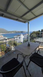 a table and chairs on a balcony with a view of the water at Emy's Rooms in Himare