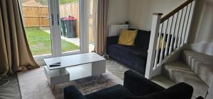 a living room with a couch and a coffee table at Private room in a 2-bedroom house in Dinnington