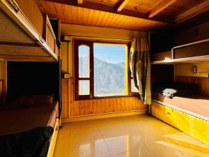 a room with two bunk beds and a window at Misfits Hostel and Cafe in Shoja